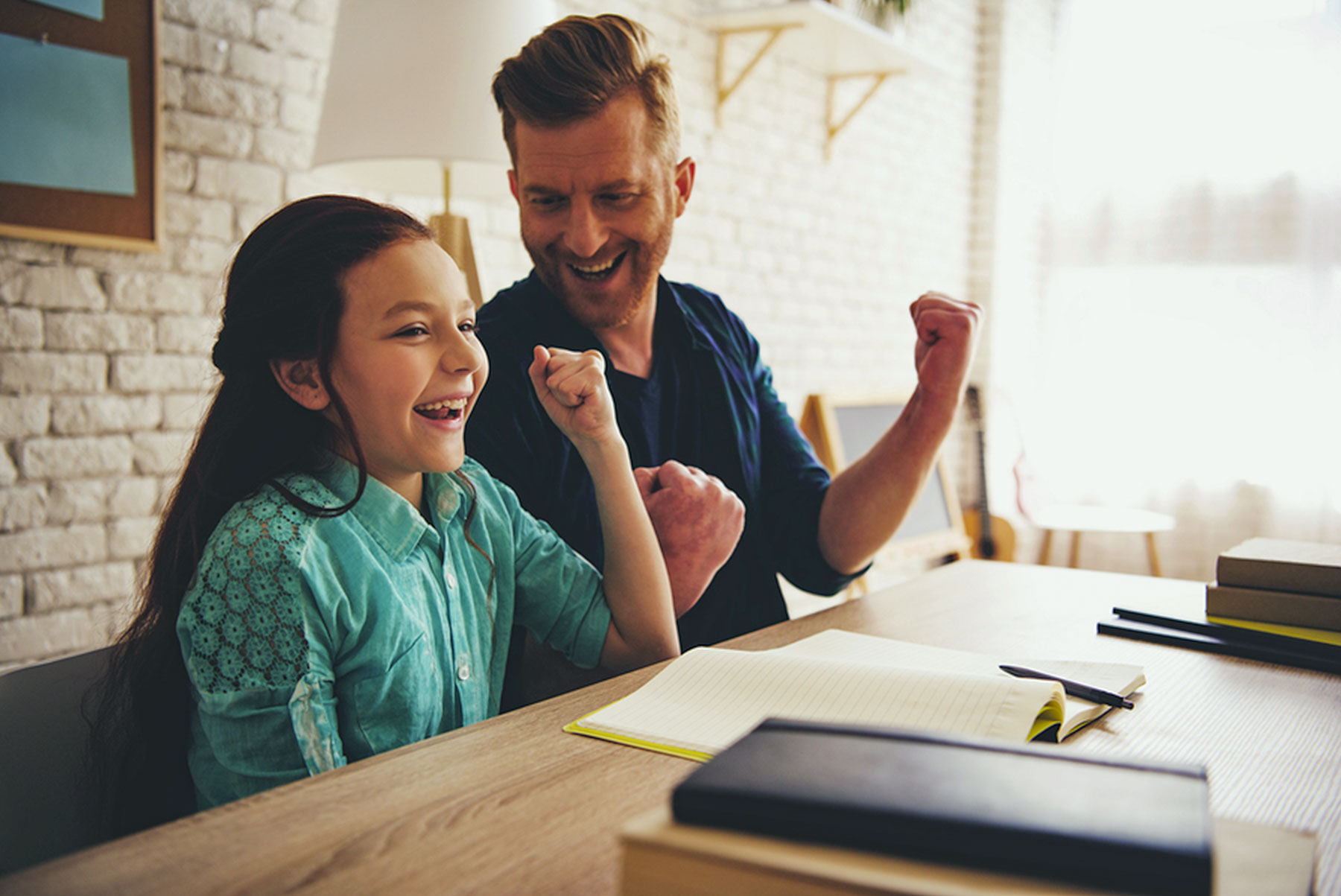 A man and girl happily cheering, the man is looking over at girl